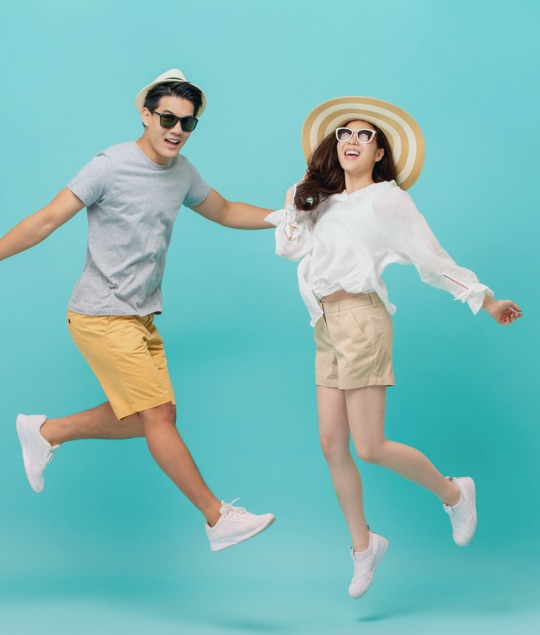 fashionable man and woman in the midst of a jump for joy